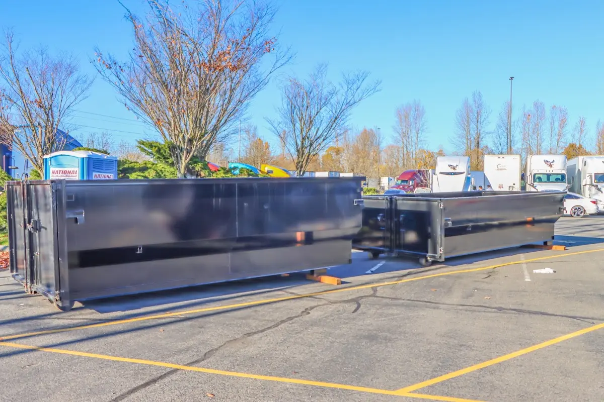 Professional dumpster rental service with roll-off container on residential driveway in Hermiston
